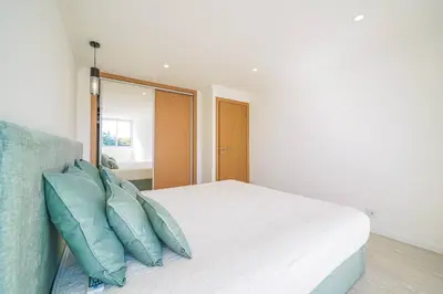 a bedroom with a white bed with blue pillows at Coral by MTPhomes in Albufeira