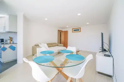a dining room with a glass table and white chairs at Coral by MTPhomes in Albufeira