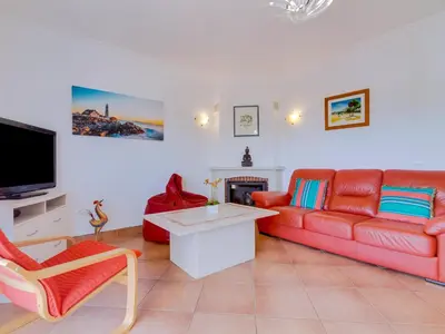 a living room with a red couch and a tv at Apartamento Mélias, 2 quartos e piscina, Vilamoura in Vilamoura