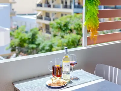 a table with a bottle of wine and a plate of food at AL - Apartamento Mira Atlantico in Quarteira