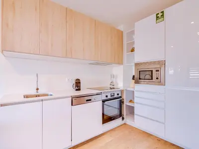 a kitchen with white appliances and wooden cabinets at AL - Apartamento Mira Atlantico in Quarteira