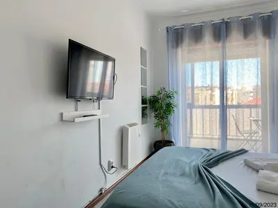 a bedroom with a bed with a flat screen tv on the wall at Blife Anya private apartment in Faro