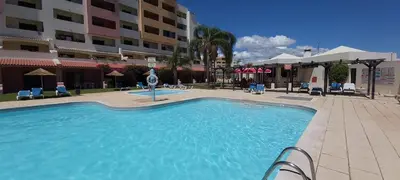 a park in front of a hotel with palm trees at Albufeira Apartment, Pool and Sea view in Albufeira