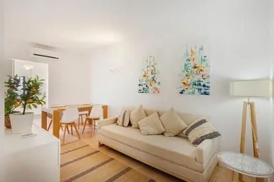 a living room with a couch and a table at Salgados Retreat -Steps from the Beach at Homesbyfc in Guia