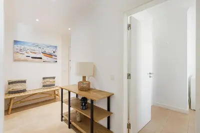 a room with a table with a lamp on it at Salgados Retreat -Steps from the Beach at Homesbyfc in Guia