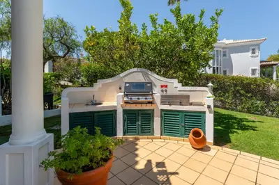 a backyard with an outdoor kitchen in a house at Villa Mia - Vale do Lobo in Vale do Lobo