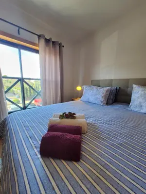 a bedroom with a large bed with towels on it at Corcovada Dream Apartment in Albufeira