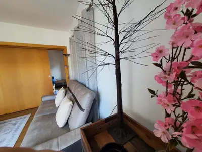 a living room with a couch and pink flowers at Corcovada Dream Apartment in Albufeira