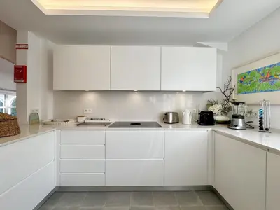 a white kitchen with white cabinets and appliances at Vilamoura Amazing Villa 2 With Pool by Homing in Vilamoura