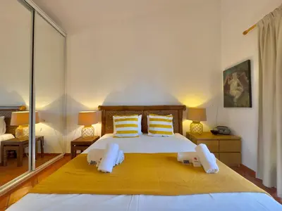 a bedroom with a large bed with yellow sheets and pillows at Vilamoura Amazing Villa 2 With Pool by Homing in Vilamoura