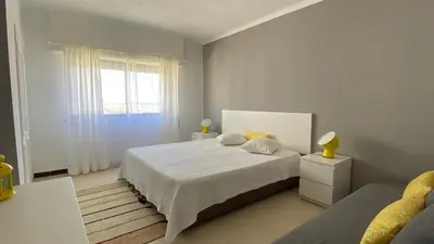 a kitchen with a wooden table and white cabinets at Sea House Apartment - Private Condo with 4 Pools, Jacuzzi & Tennis Court in Albufeira
