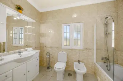 a bathroom with a toilet and a sink and a shower at Villa Caly by Villa Plus in Roja- Pé