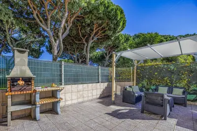 a patio with a fireplace and an umbrella and chairs at Villa Caly by Villa Plus in Roja- Pé
