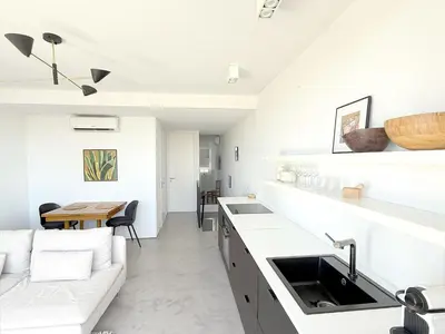 a white bedroom with a large white bed and two lamps at 1BR with Panoramic View in historic centre Loulé in Loulé