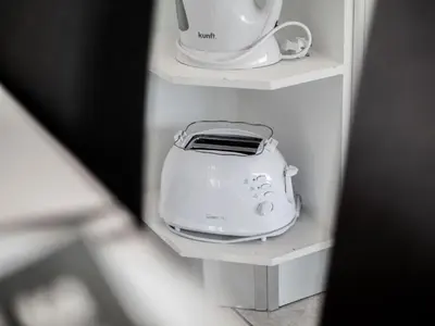a white toaster is sitting on a shelf at Let the sun come in - walking to the beach by Algarve Dream Holidays in Albufeira
