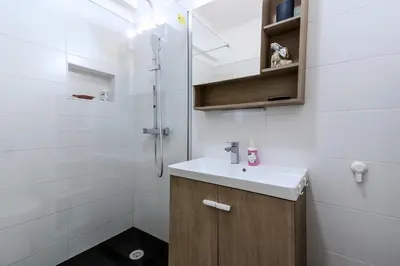 a white bathroom with a sink and a shower at #344 Edificio Marina Sol by Home Holidays in Branqueira