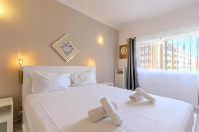 a bedroom with a white bed with two towels on it at #344 Edificio Marina Sol by Home Holidays in Branqueira