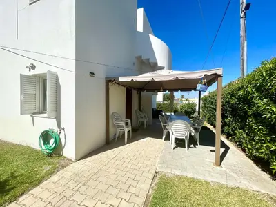 a patio with a table and an umbrella at Villa Jose in Olhos de Água