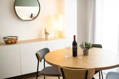 a dining room table with two wine glasses and a mirror at LIA - Quarteira in Quarteira