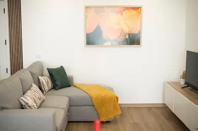a living room with a couch and a painting on the wall at LIA - Quarteira in Quarteira