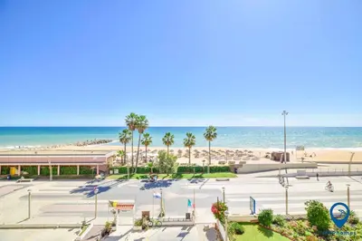 a parking lot with the beach in the background at Praia Mar by MTPhomes in Quarteira