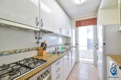 a white kitchen with a stove and a sink at Praia Mar by MTPhomes in Quarteira