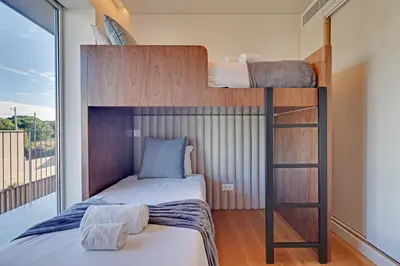 a bedroom with two bunk beds and a balcony at New Beach Apartment in Quarteira