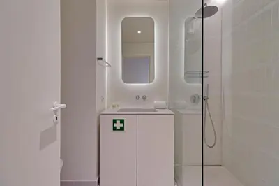 a white bathroom with a sink and a shower at New Beach Apartment in Quarteira