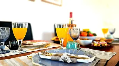 a table with glasses of orange juice and a plate of food at Espaço Luzitano, fabulous and stylish spot, Faro city center, Wi-fi in Faro