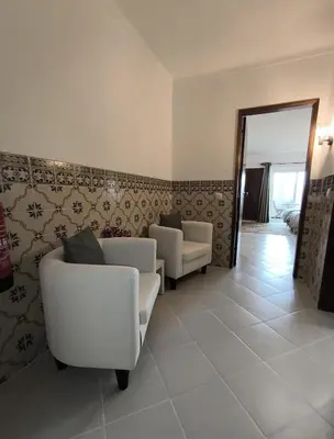 a living room with two white chairs and a mirror at JC HOUSE - T0 - Smart Stay Albufeira - BY BEDZY in Albufeira