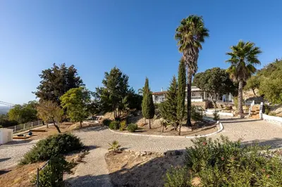a park with palm trees and a building at Villa e5 in Tunes