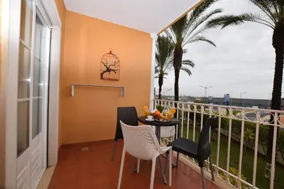 a balcony with a table and chairs and palm trees at Apartamento Albufeira in Albufeira