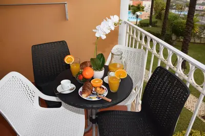 a table with a plate of food and orange juice at Apartamento Albufeira in Albufeira