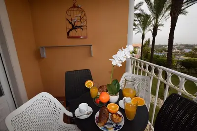 a table with a plate of food on a balcony at Apartamento Albufeira in Albufeira
