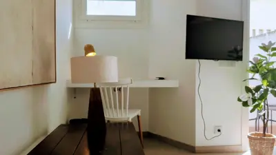 a living room with a chair and a television at Albufeira Spring, Summer & Fall in Albufeira