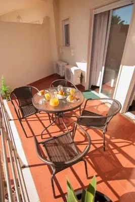 a table and chairs on a balcony with food on it at Apartamento Albufeira- Descobrimentos in Albufeira