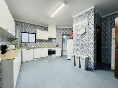 a kitchen with white cabinets and blue and white tiles at Vilamoura Summer Villa 2 With Pool by Homing in Vilamoura