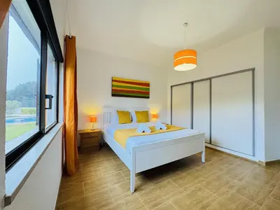 a bedroom with a bed and a large window at Vilamoura Summer Villa 2 With Pool by Homing in Vilamoura