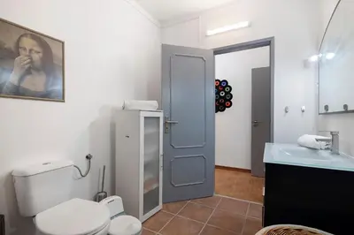 a bathroom with a toilet and a sink and a mirror at Habemus Domu Albufeira in Albufeira