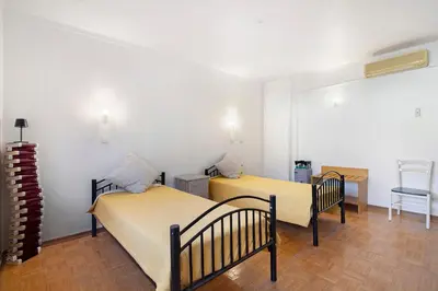 two beds in a room with a table and a chair at Habemus Domu Albufeira in Albufeira