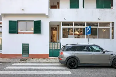 a car parked in front of a building with a parking sign at Habemus Domu Albufeira in Albufeira