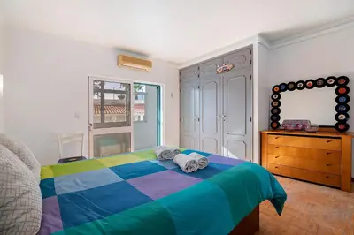 a bedroom with a colorful bed and a window at Habemus Domu Albufeira in Albufeira
