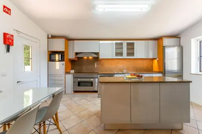 a kitchen with white cabinets and a counter top at Monte Da Poupa - 7 bedroom villa - Sleeps 15 in Albufeira