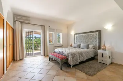 a bedroom with a bed and a large window at Monte Da Poupa - 7 bedroom villa - Sleeps 15 in Albufeira
