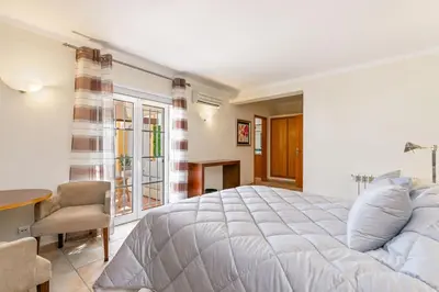 a bedroom with a large bed and a table and chair at Monte Da Poupa - 7 bedroom villa - Sleeps 15 in Albufeira