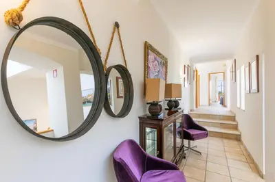 a hallway with purple chairs and a mirror at Monte Da Poupa - 7 bedroom villa - Sleeps 15 in Albufeira