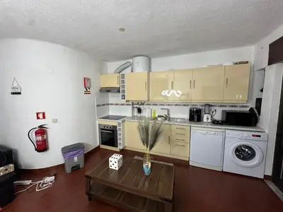 a kitchen with wooden cabinets and a stainless steel refrigerator at Casa Lopes in Albufeira