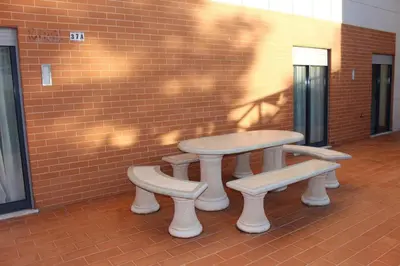 a table and two benches next to a brick wall at Spacious apartment in Albufeira 200 m² with shared pool in Albufeira