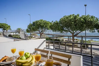 a table with food on a balcony with a view of the ocean at #351 Edificio Marina 1 D by Home Holidays in Páteo