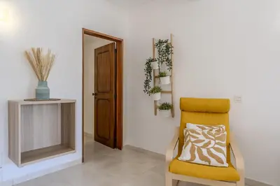 a yellow chair in a room with a mirror at #351 Edificio Marina 1 D by Home Holidays in Páteo